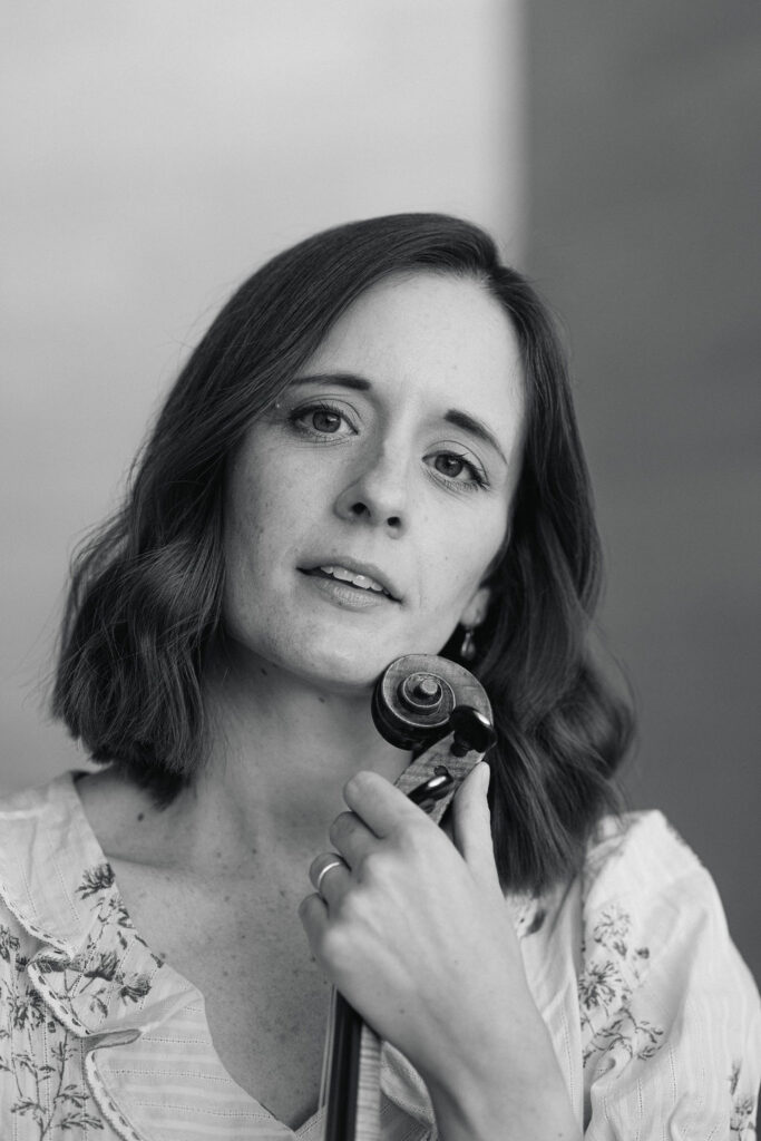 Close-up portrait of DC violinist Emily holding her violin black and white