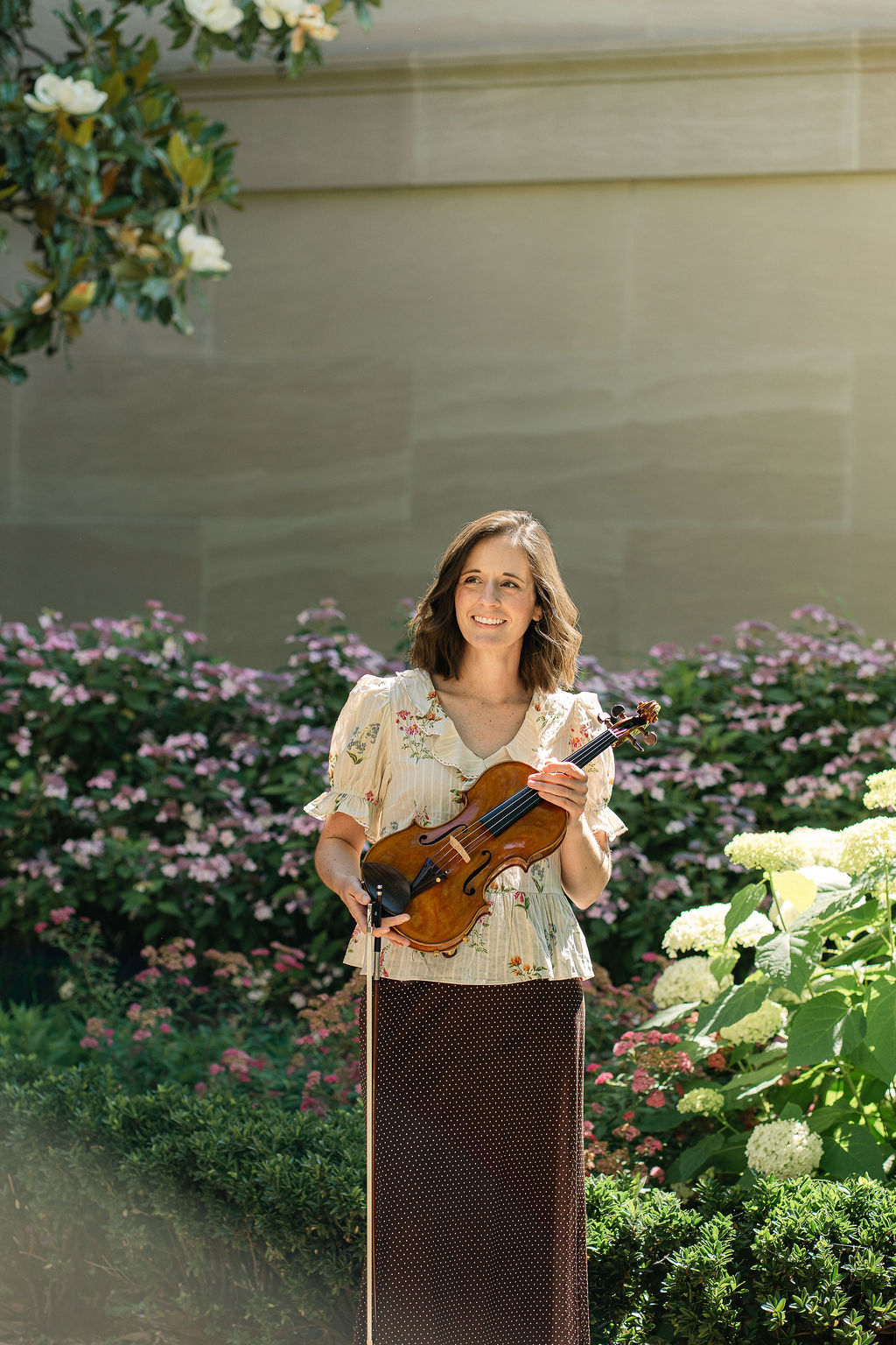 Emily with her violin surrounded by flowers outside the National Gallery of Art