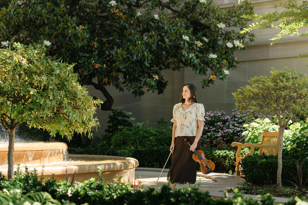 Portrait of a violinist with her instrument outside an art gallery in Washington, DC