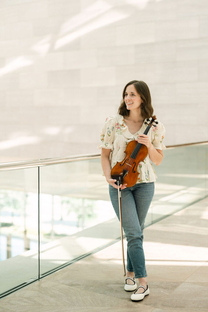 Violinist Emily standing with her violin at the National Gallery of Art in Washington, DC