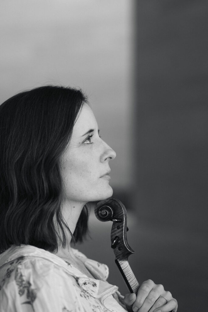 Side profile of Emily with her violin black and white