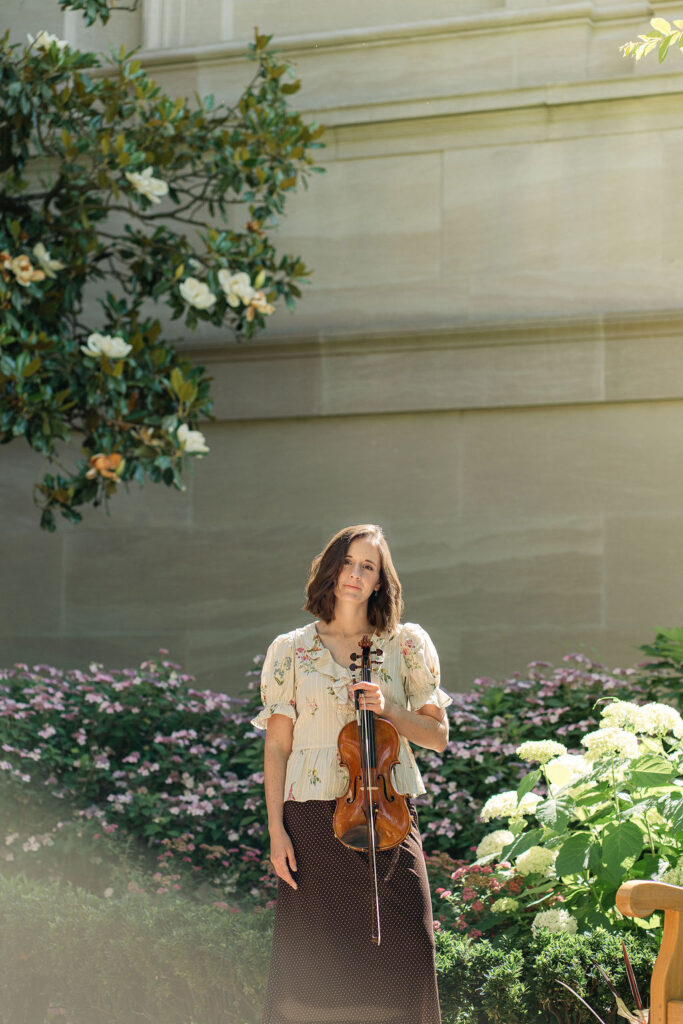 Emily with her violin surrounded by flowers outside the National Gallery of Art