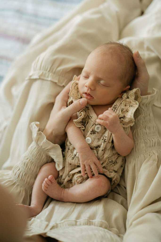 Sleeping newborn baby in her mother's lap