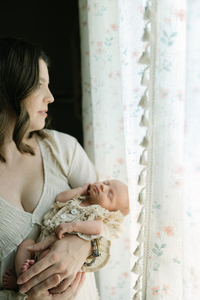 Mother holding her newborn baby in a bright nursery