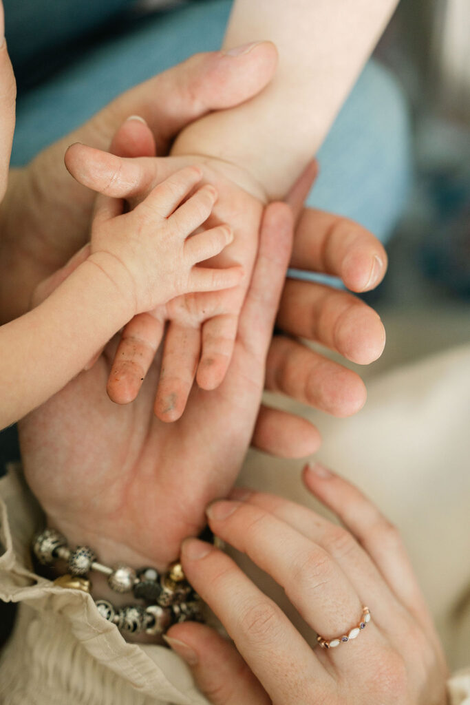 Family of four holding hands