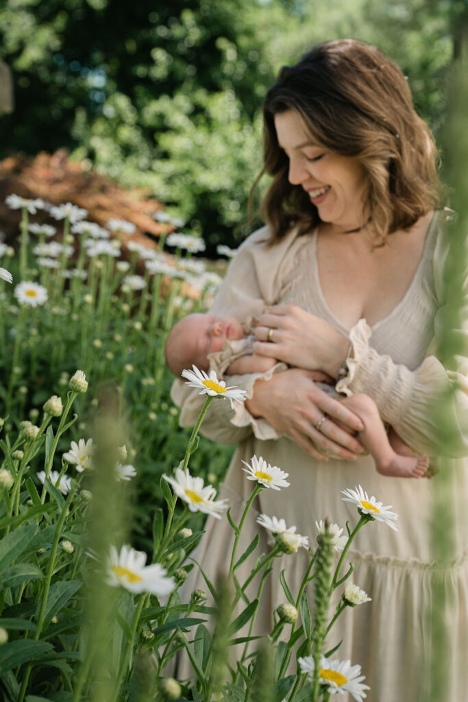Mother holding her newborn baby in a garden