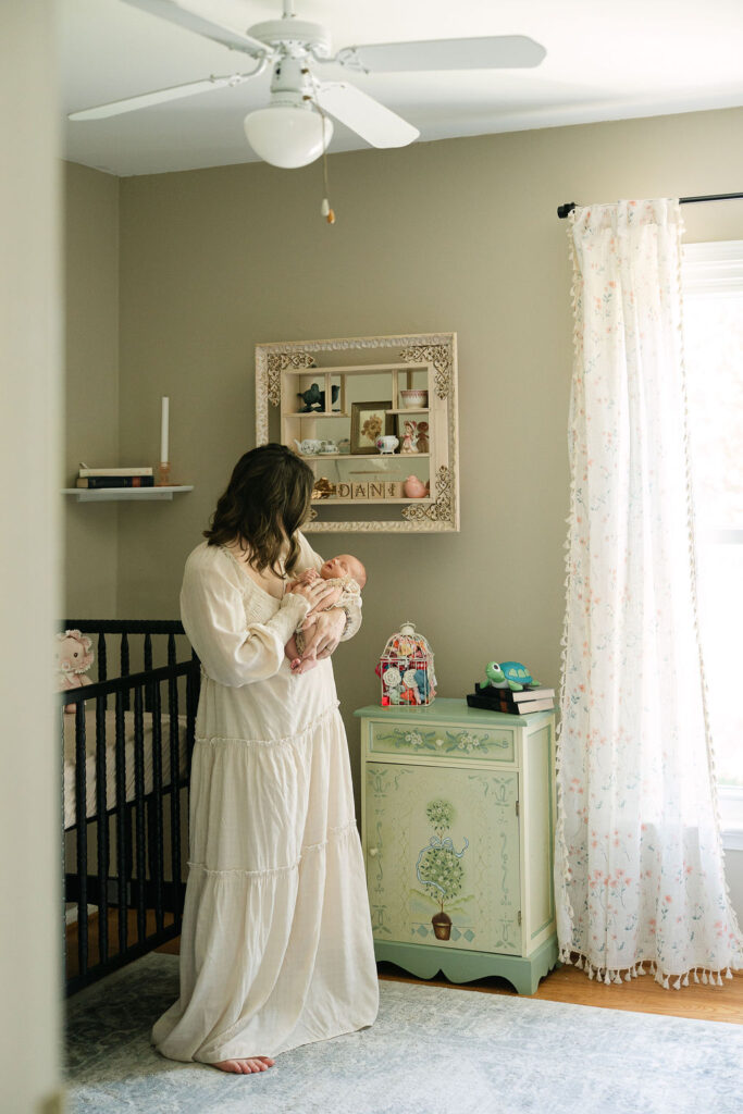 Mother holding her newborn baby in a bright nursery