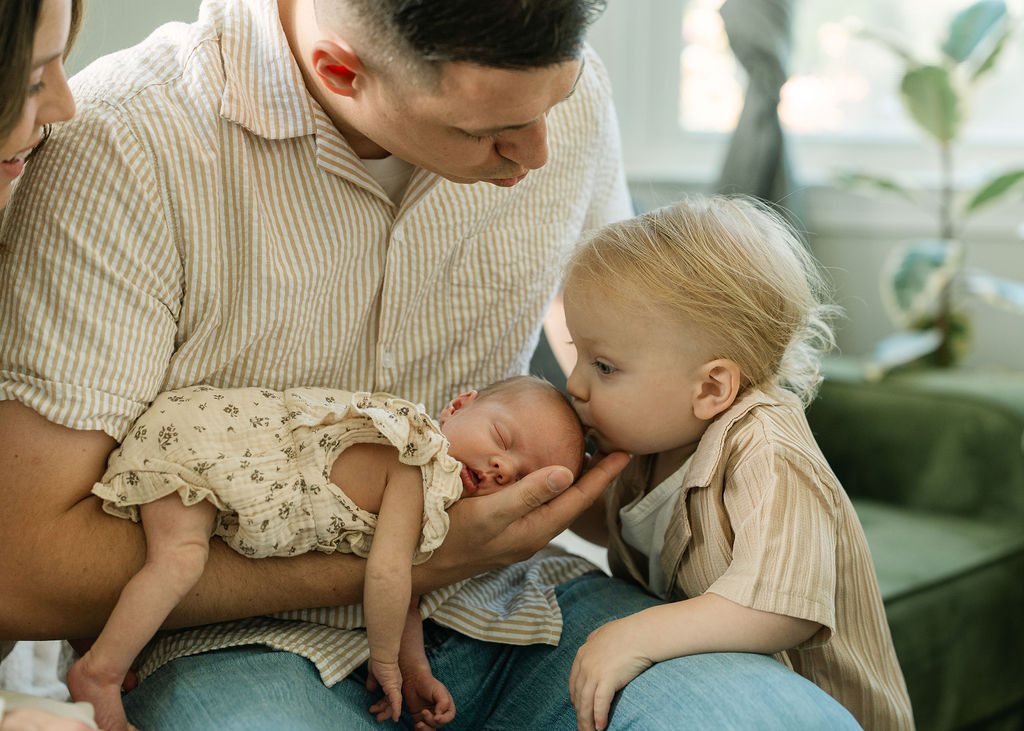 Big brother kissing his baby sister