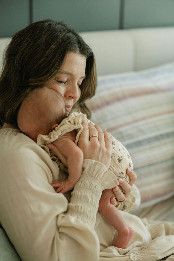 Mother cuddling her newborn daughter at home