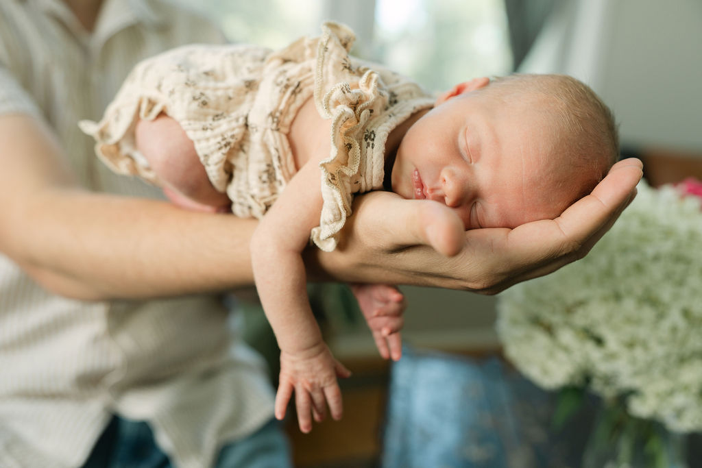 Father holding his newborn baby during an in-home session