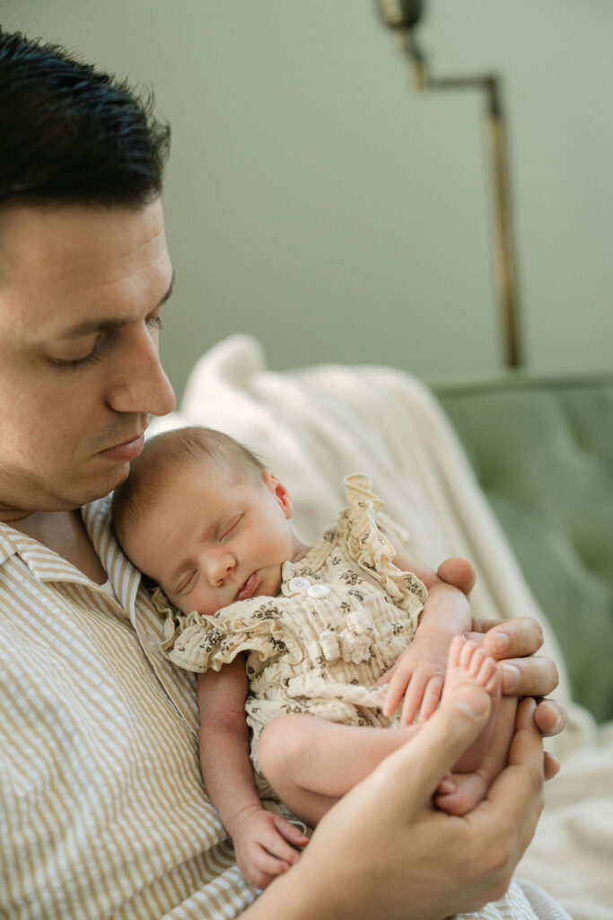 Father holding his newborn baby during an in-home session