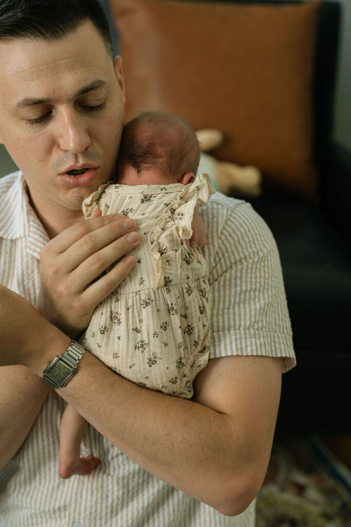 Father gently kissing his newborn baby