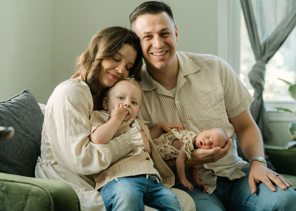 Family of four cuddling together during an in-home newborn session