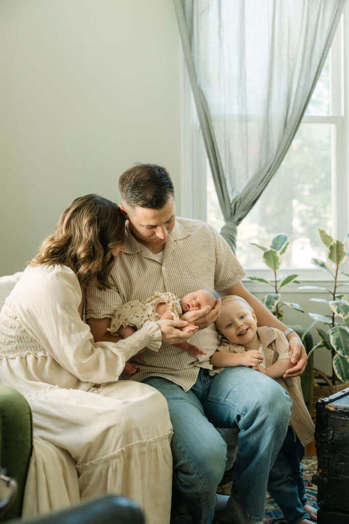 Family of four cuddling together during an in-home newborn session